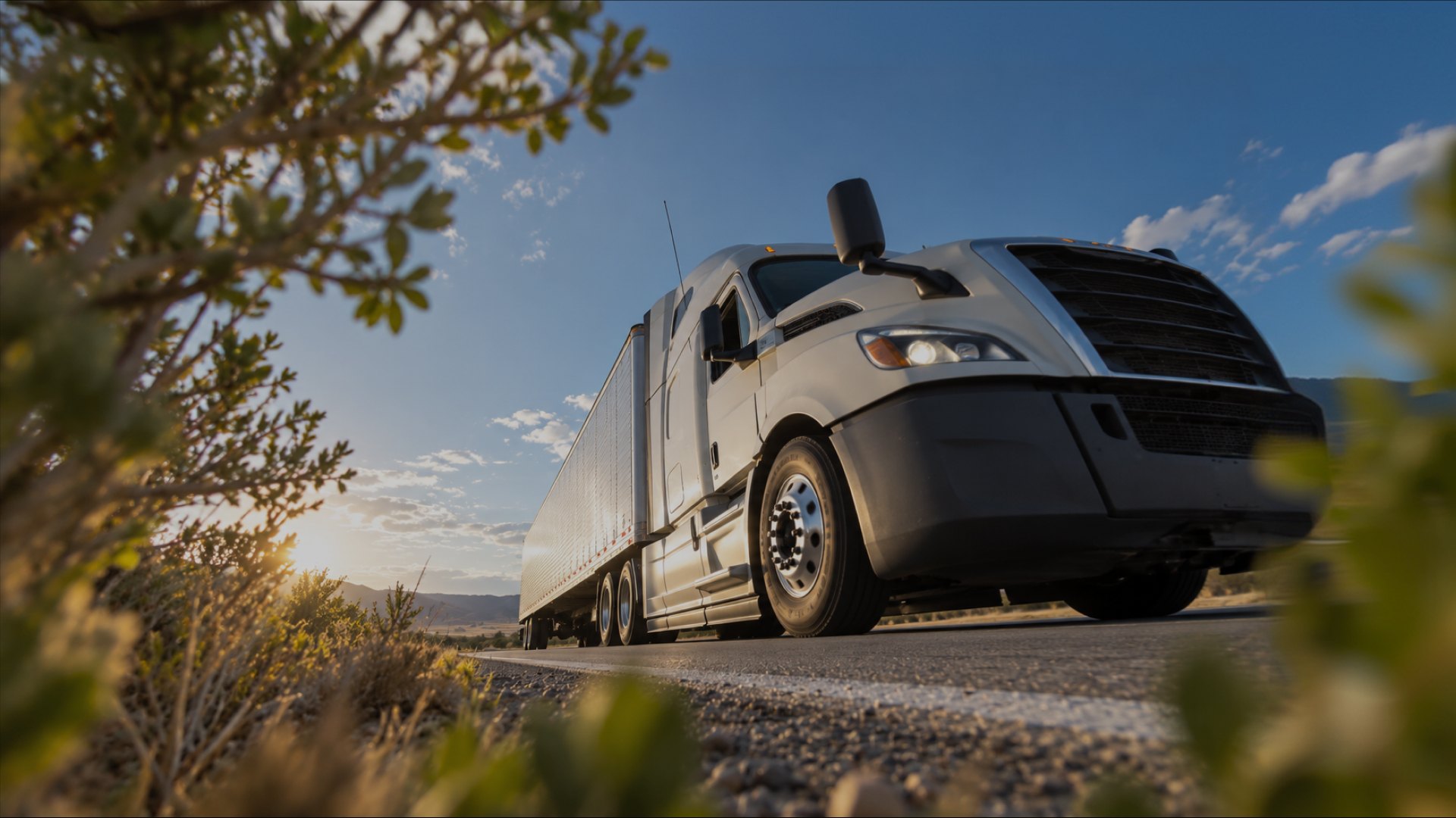 An articulated lorry on a highway at golden hour