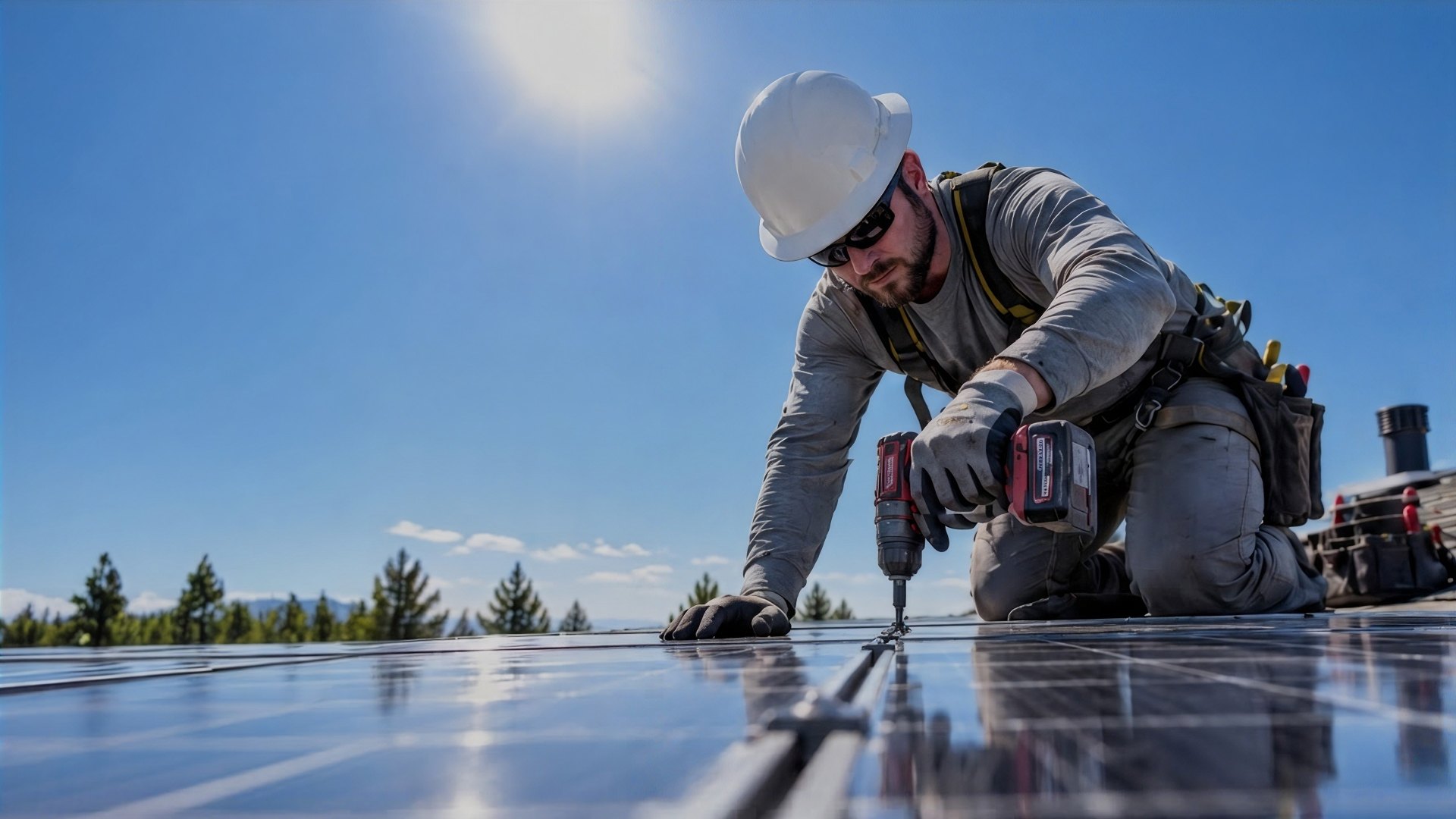 An installer fixing a solar panel on a roof under a clear sky
